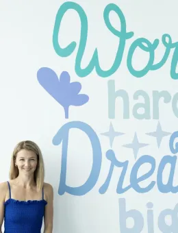 Katy Finlay in front of the VPS Work Hard Dream Big mural