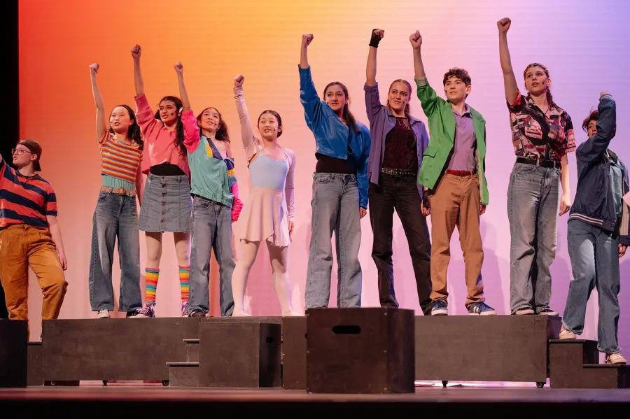 VPS Inspire Musical Company — teen performers with fists raised during a production