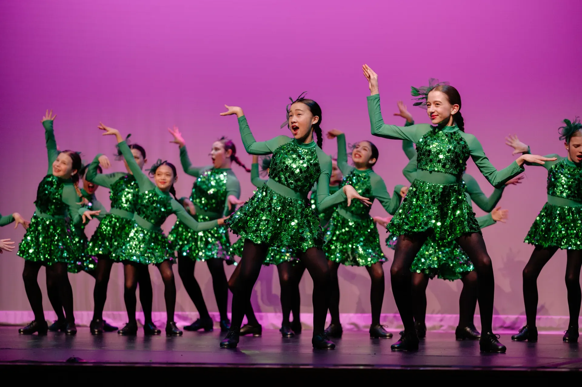 Starjump Academy jazz ensemble performing on stage in green sequin costumes
