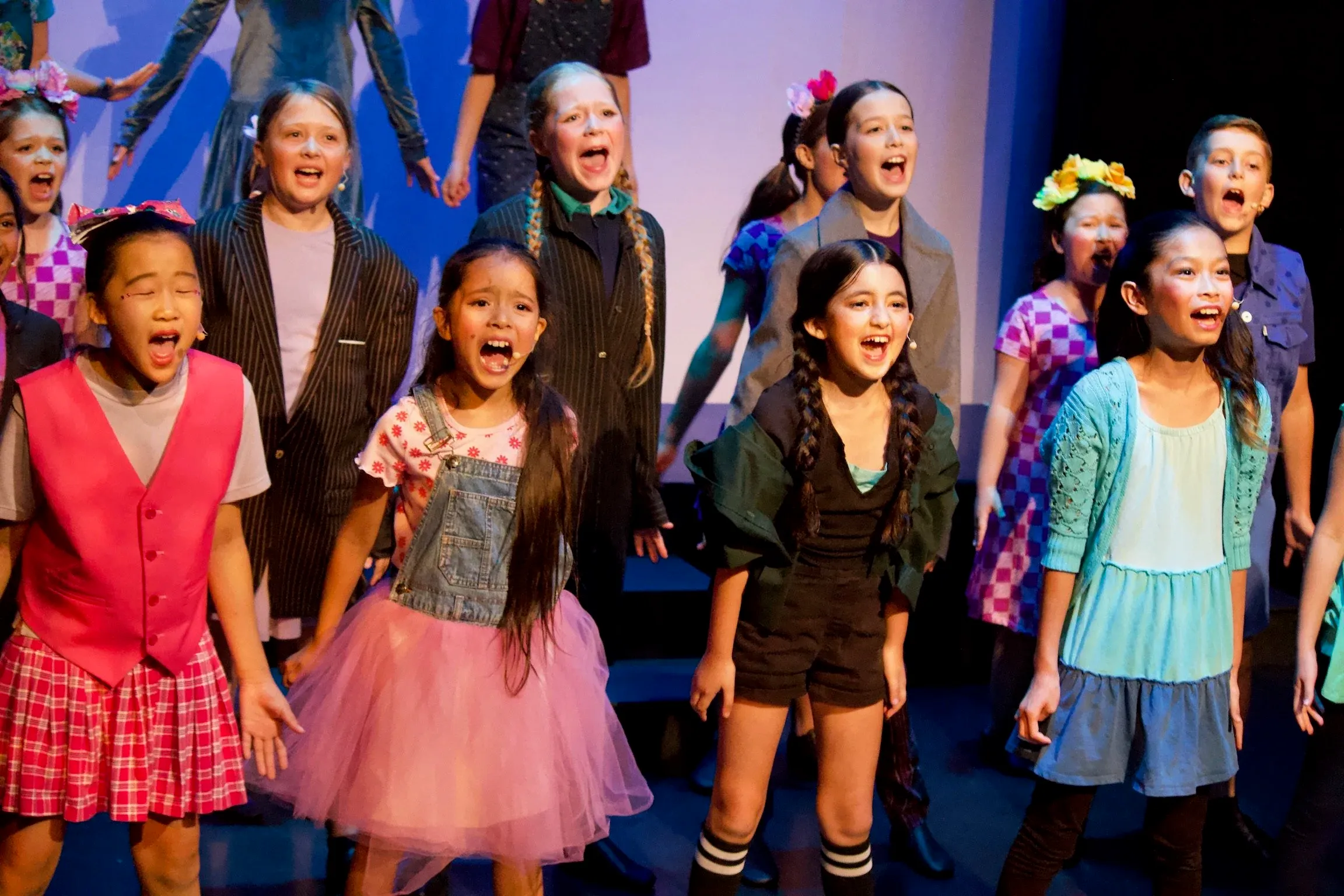 VPS campers singing together on stage during a summer musical theatre camp performance
