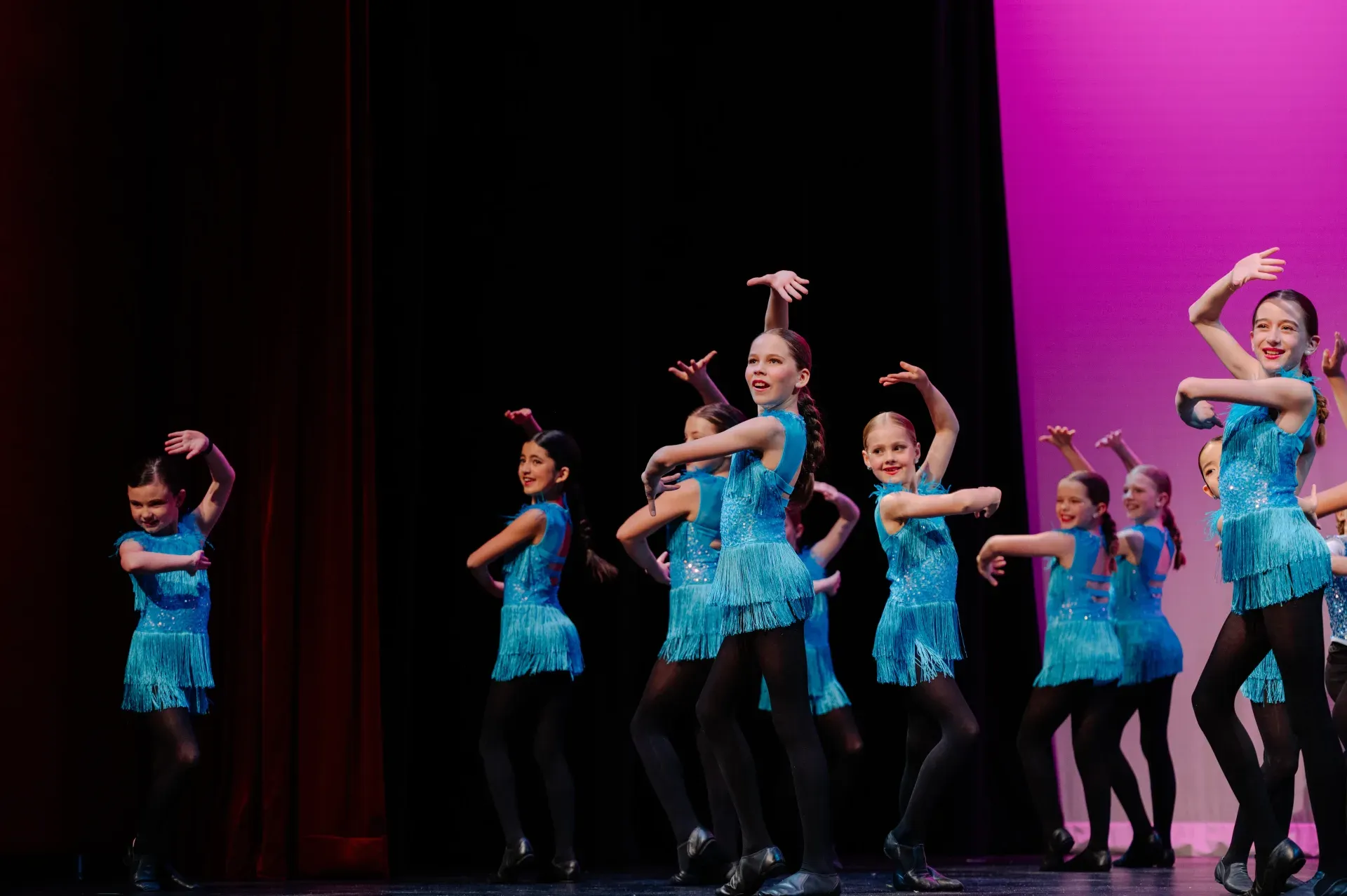 VPS jazz and tap students performing on stage in teal fringe costumes